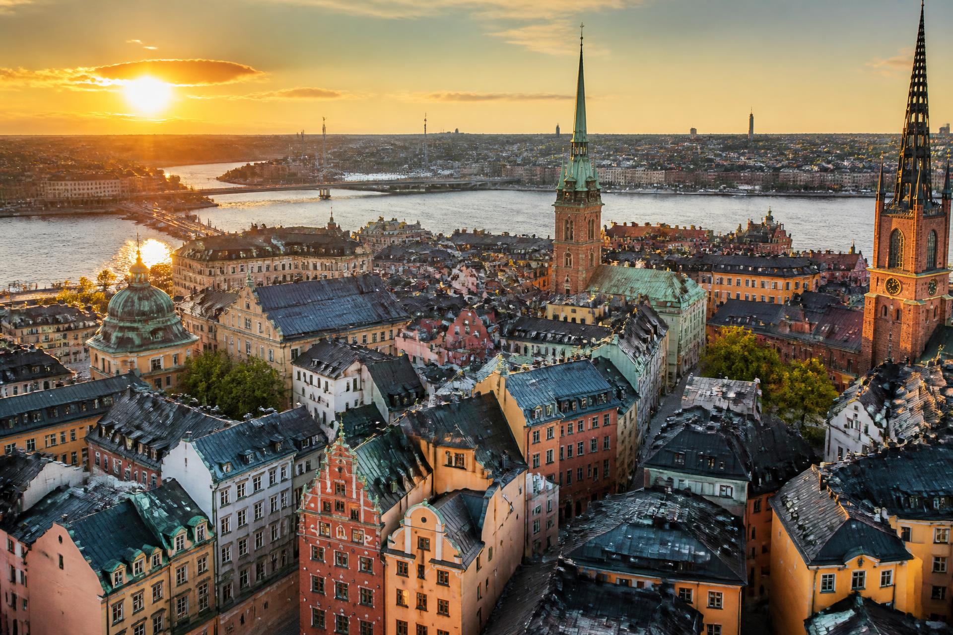 Vy över Stockholms takåsar och Gamla stan i solnedgång